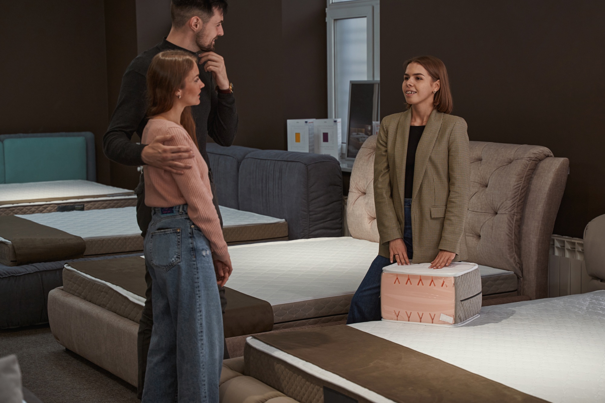 Young shoppers choosing new mattress for bed
